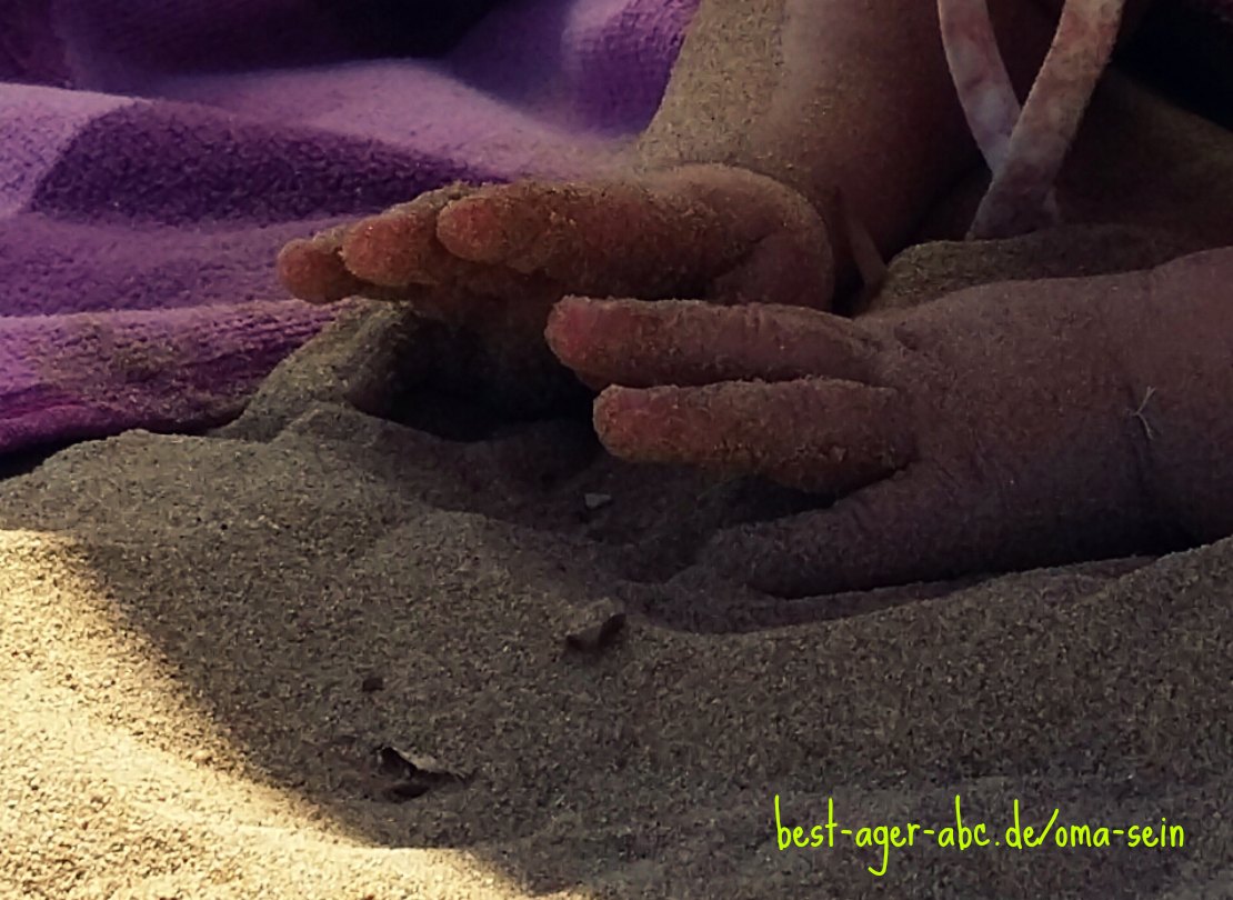 Babyhände im Sand